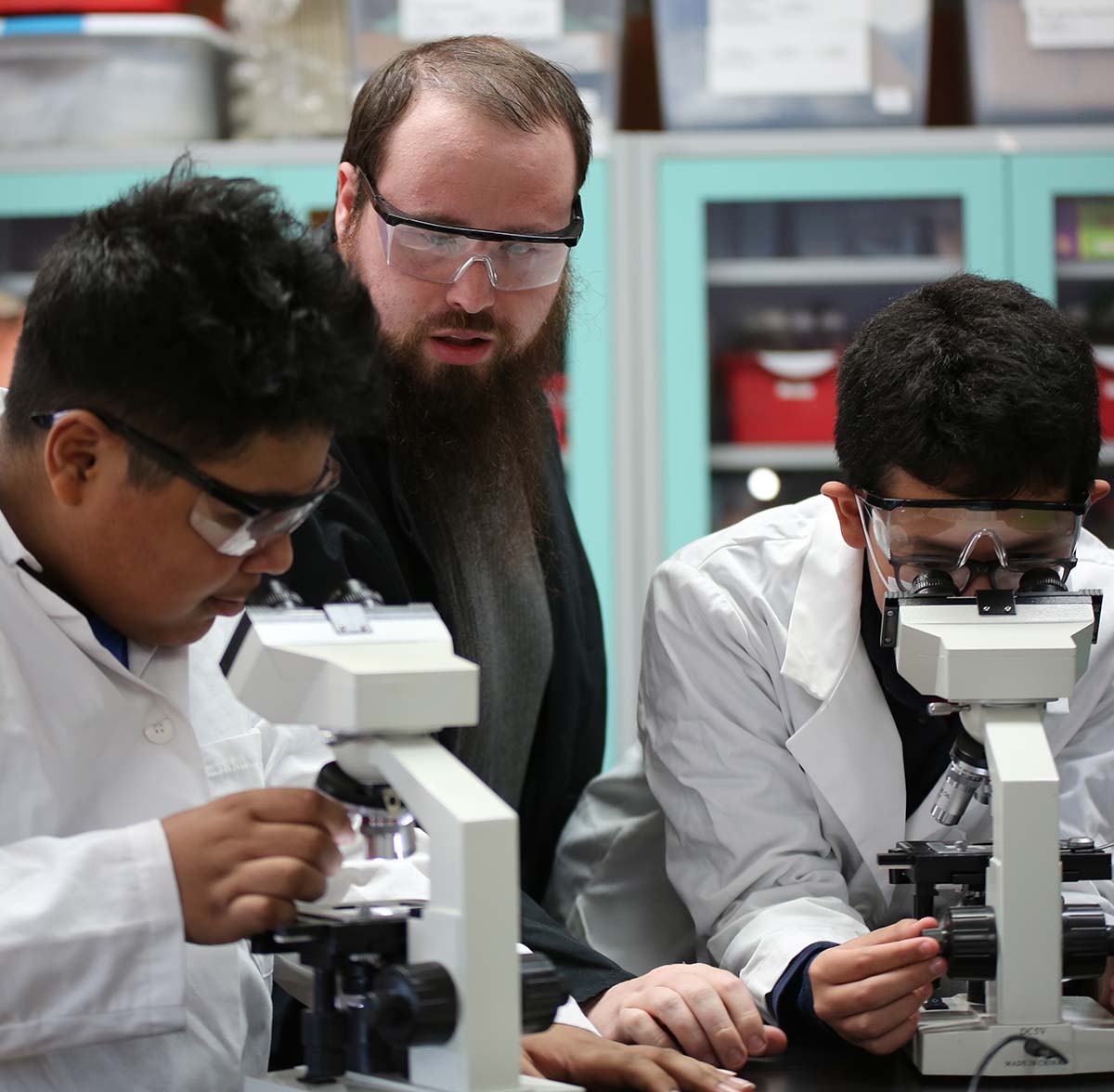 HSA Belmont Teacher and student interacting at a classroom desk